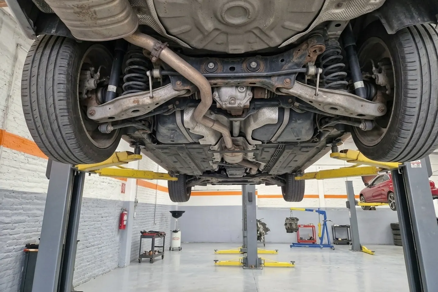 Suspensión trasera de un sedán europeo vista desde abajo en el elevador