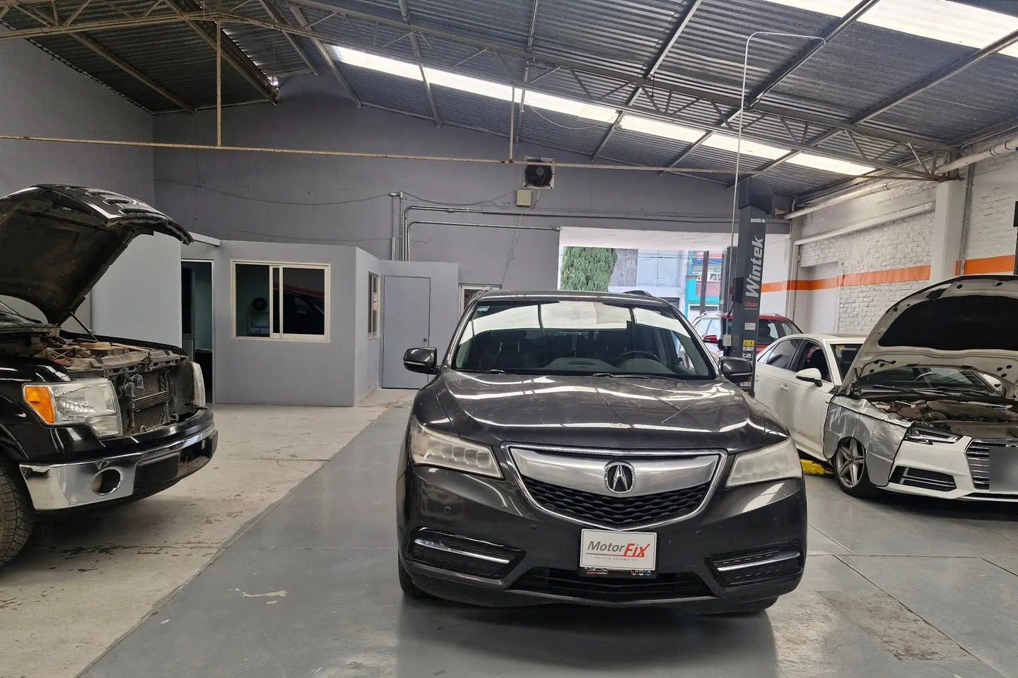 Área de trabajo del taller Motorfix con varios autos en servicio